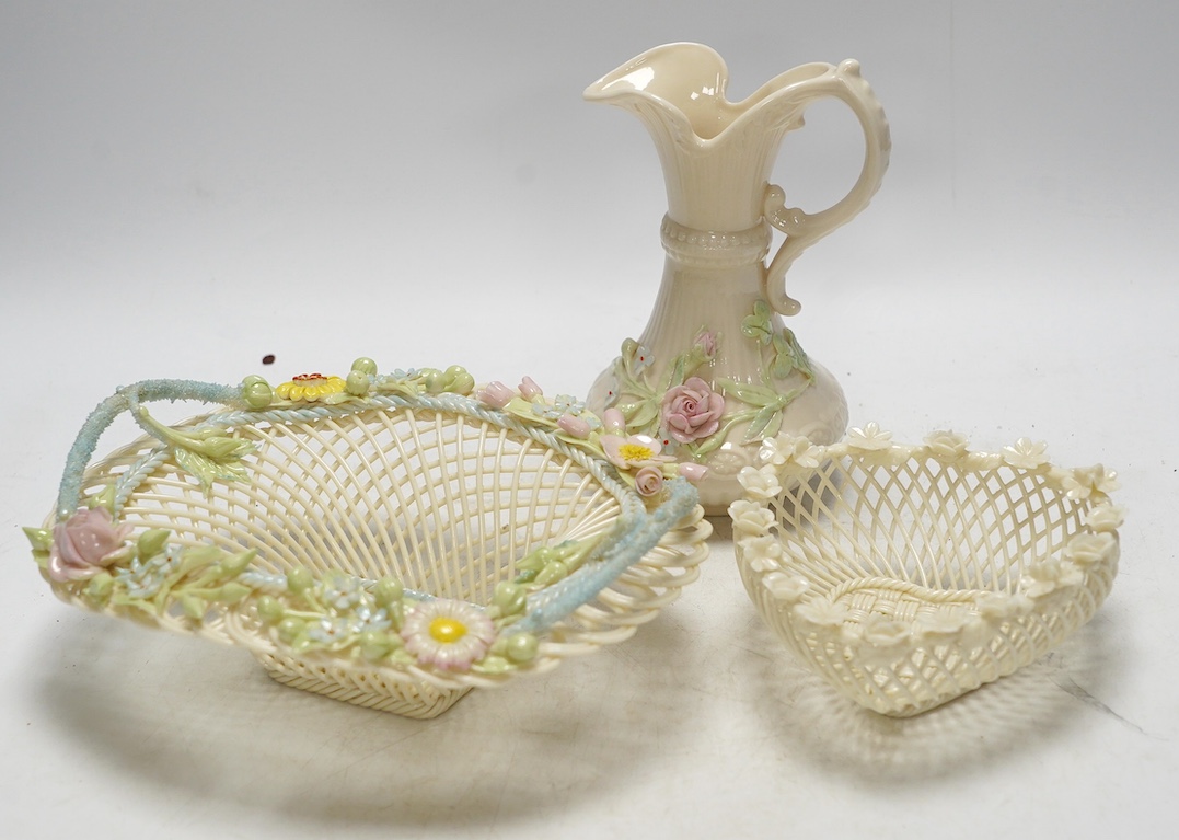 Three 20th century Belleek items with applied floral decorations; a jug, 15cm high, and two basket work dishes, largest 20cm wide. Condition - good